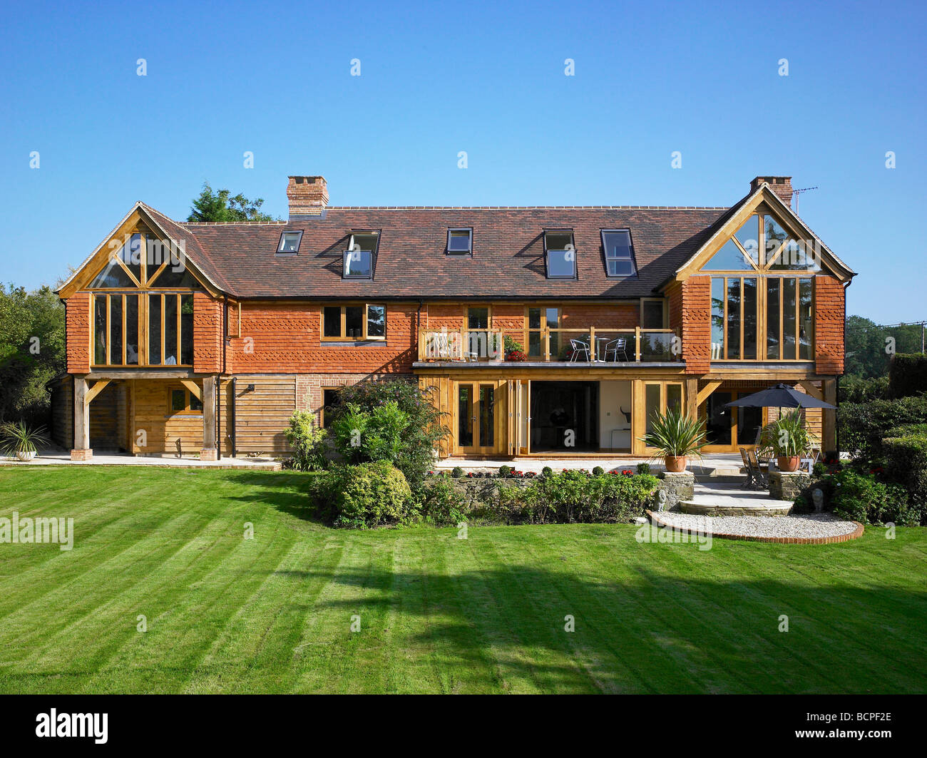 Exterior of a large refurbished house with 'bifold' doors, velux windows and lots of glass. Stock Photo