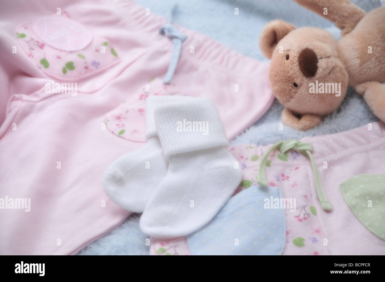 Close up of baby clothes with traditional teddy bear Stock Photo - Alamy