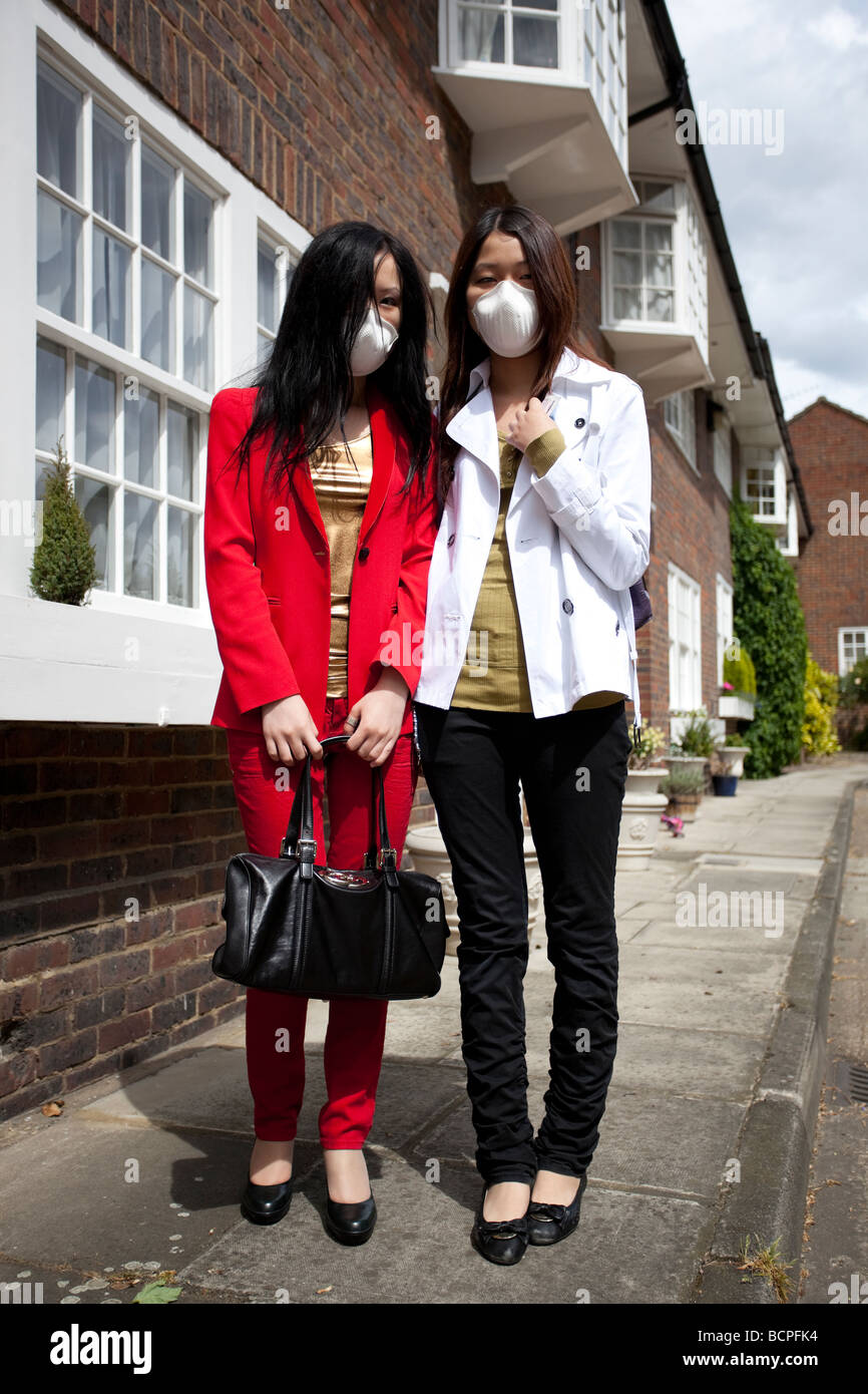 Two Japanese women wearing anti-virus masks, London, England, UK. Stock Photo