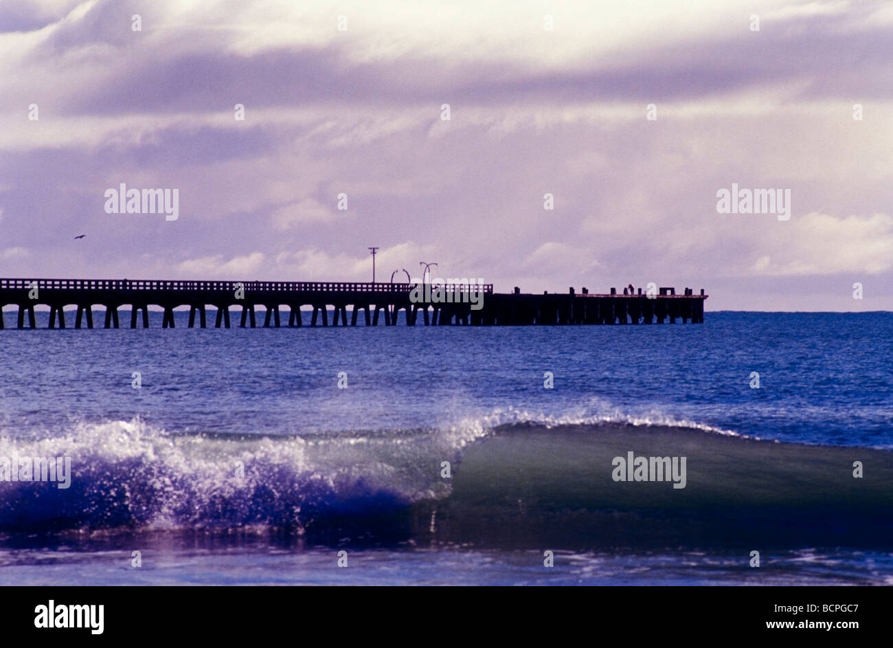 Tolaga Bay with wharf with small wave breaking on the beach in the