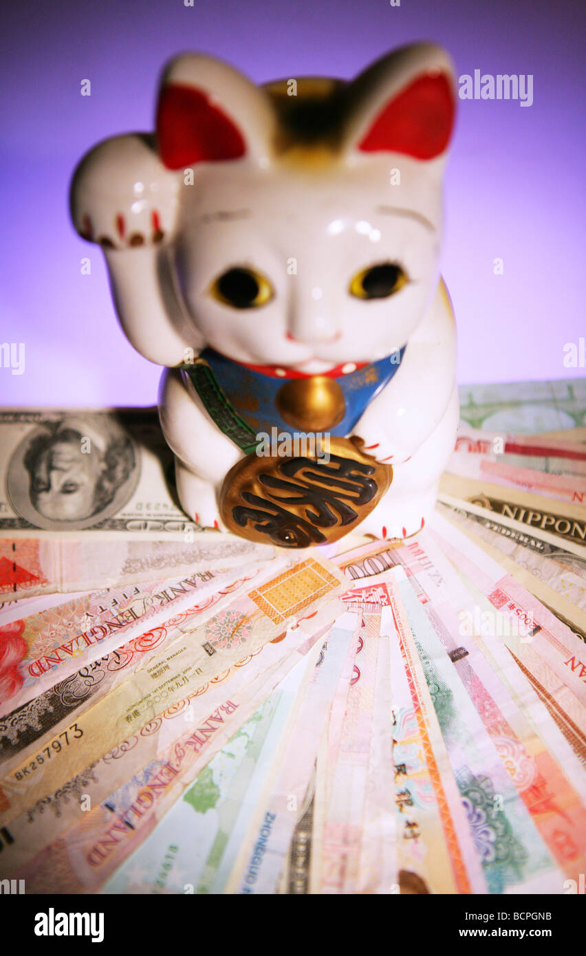 Different currencies and fortune cat Stock Photo