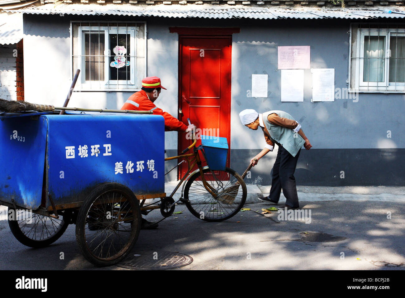 Janitors cleaning street in a Hutong, Beijing, China Stock Photo