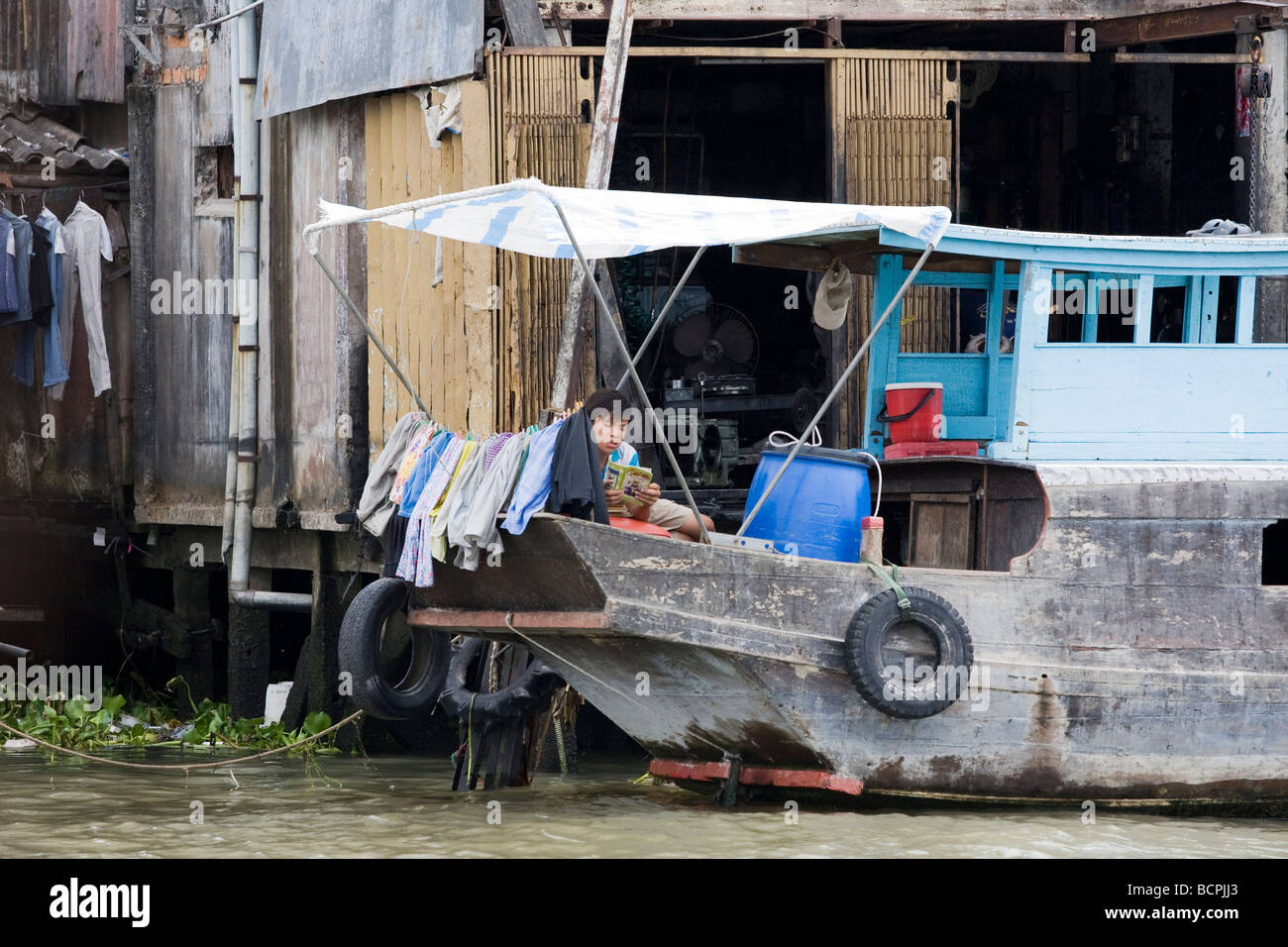 A man on a boat in a floating village in the Mekong Delta, Vietnam ...