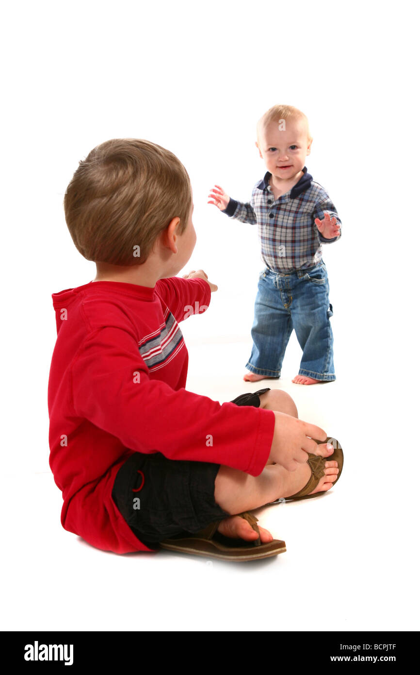 Older Brother Urging Younger Child to Come to Him Stock Photo