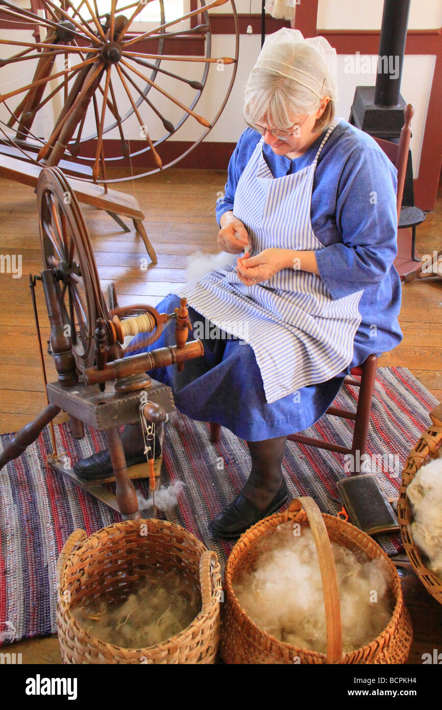 Costumed interpreter spins yarn at East Family Sisters Shop at Shaker Village of Pleasant Hill Harrodsburg Kentucky Stock Photo