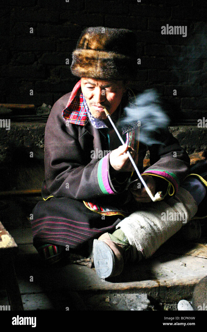 Baima Tibetan man smoking tobacco pipe, Pingwu County, Mianyang, Sichuan Province, China Stock Photo