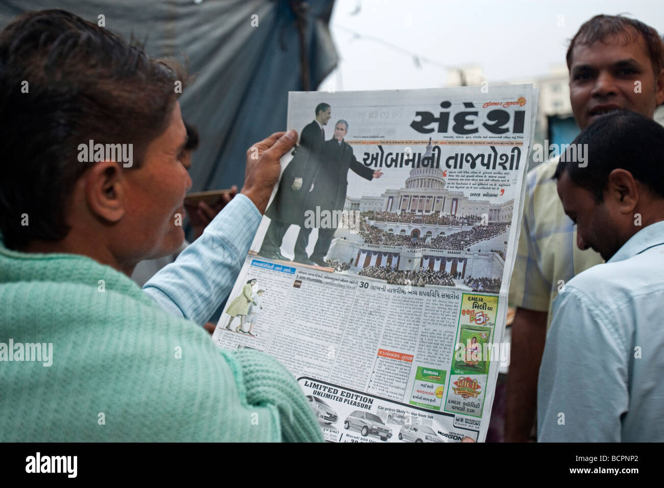 Man reading Gujarati newspaper story of Barack Obama US presidential inauguration Bhavnagar India Stock Photo