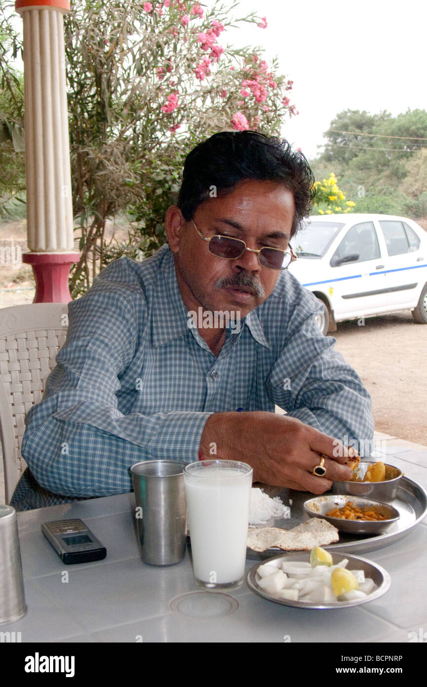 Businessman eats lunch with hand India Stock Photo - Alamy