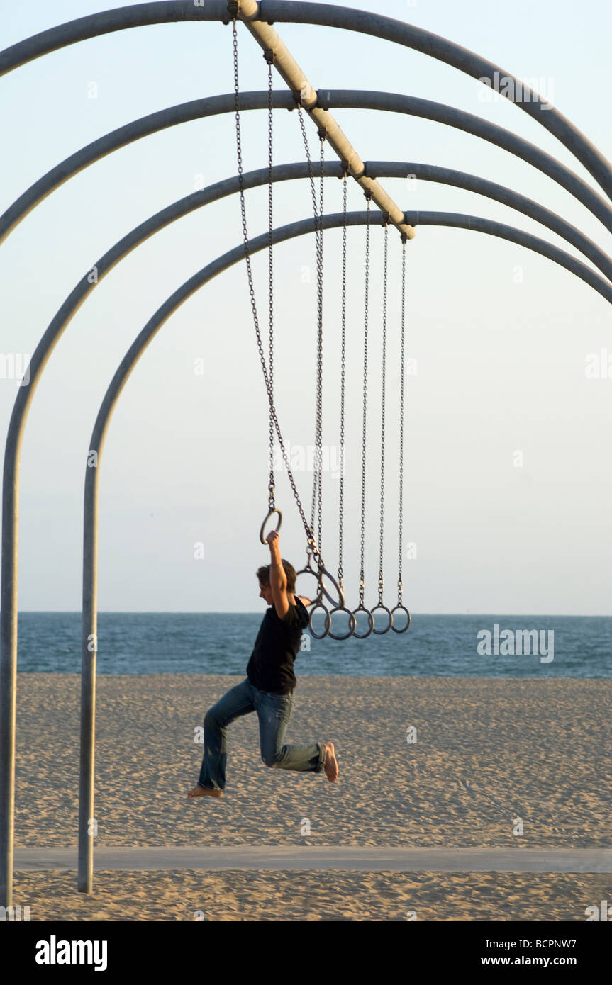 Boy playing on rings at beach Stock Photo - Alamy
