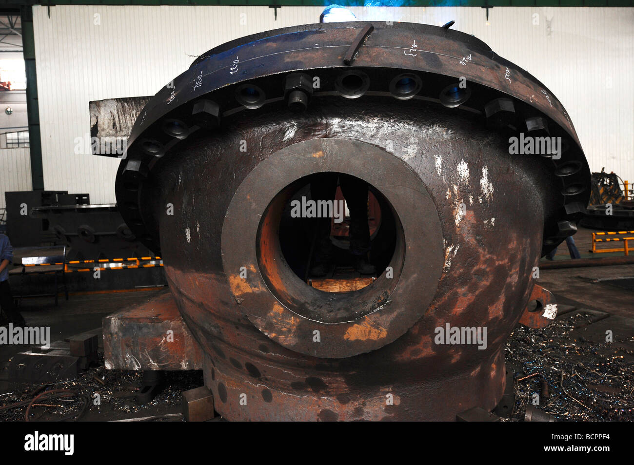 Engineer works inside the cavity of an unfinished machinery part ...