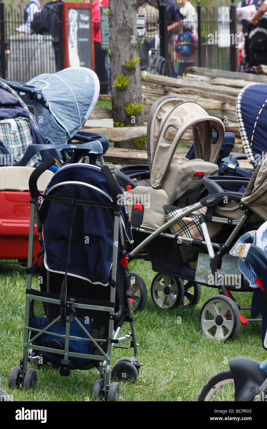 Several child empty strollers stand in the public park nobody none outside outdoors from above overhead top view  vertical in USA hi-res Stock Photo