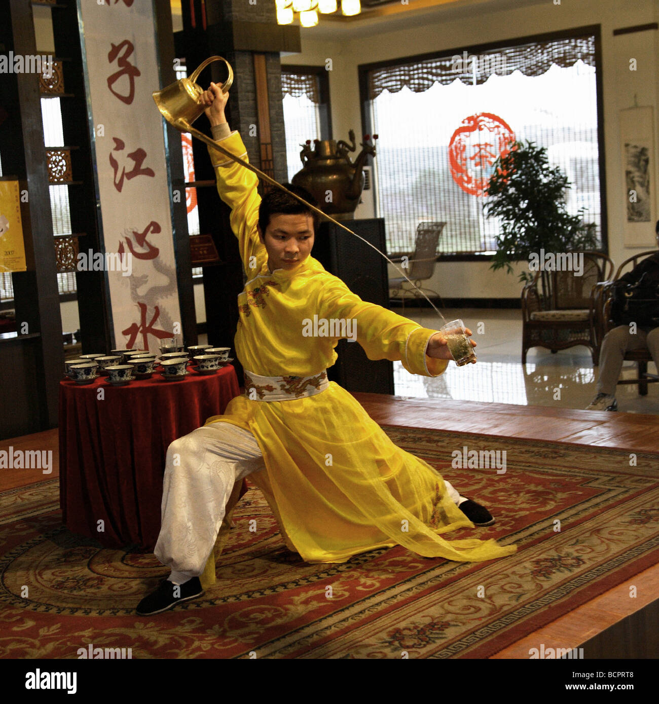Lim Ba Waiter in traditional Cheong-sam performing tea ceremony using ...