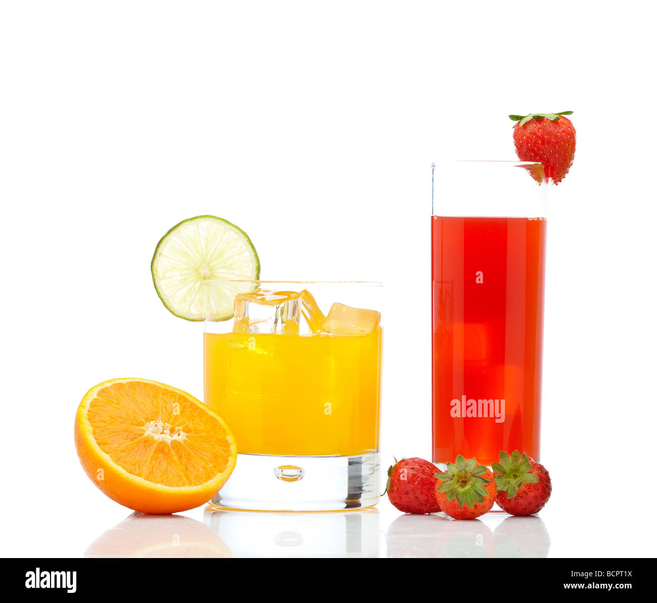 A glass of orange juice with a lime slice and strawberry juice ...