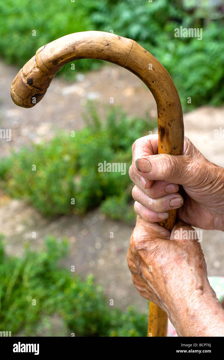 hands of an old peasant woman holding a walking stick Stock Photo