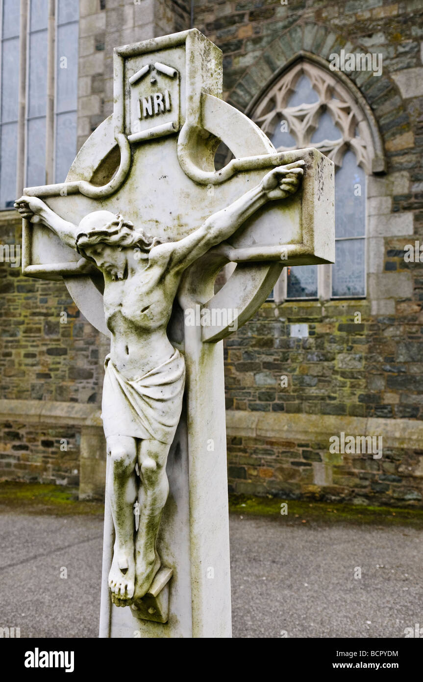 Marble crucifix gravestone in a church graveyard Stock Photo