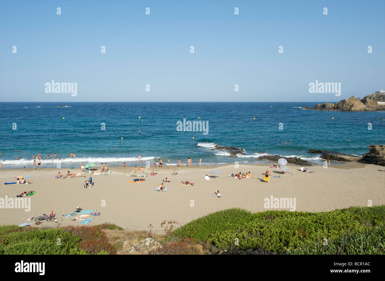 Tourists sun bathe on the beach at Cala Mesquida near Mahon on the Balearic island of Menorca Stock Photo