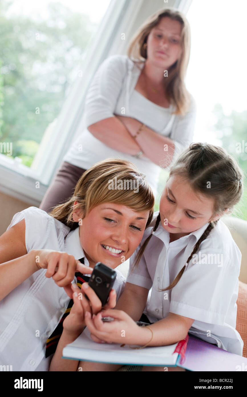 2 girls looking at message on a mobile phone Stock Photo