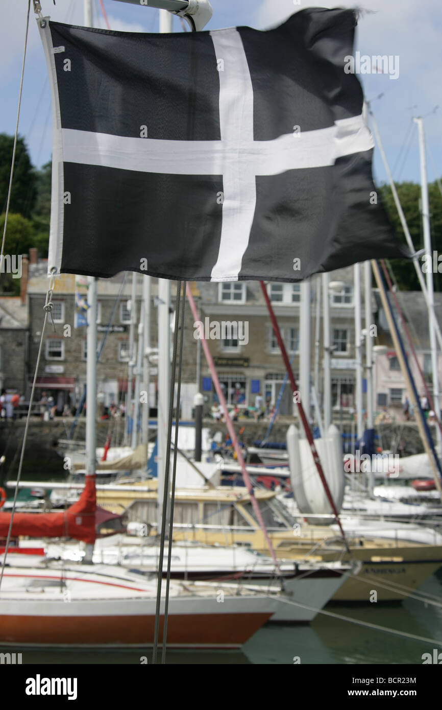 Town of Padstow, England. Cornish flag flying on a boat in Padstow Harbour with leisure boats out of focus in the background. Stock Photo