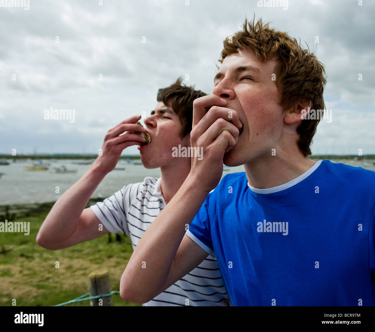 Two young males eating oysters for the first time. Photo by Gordon