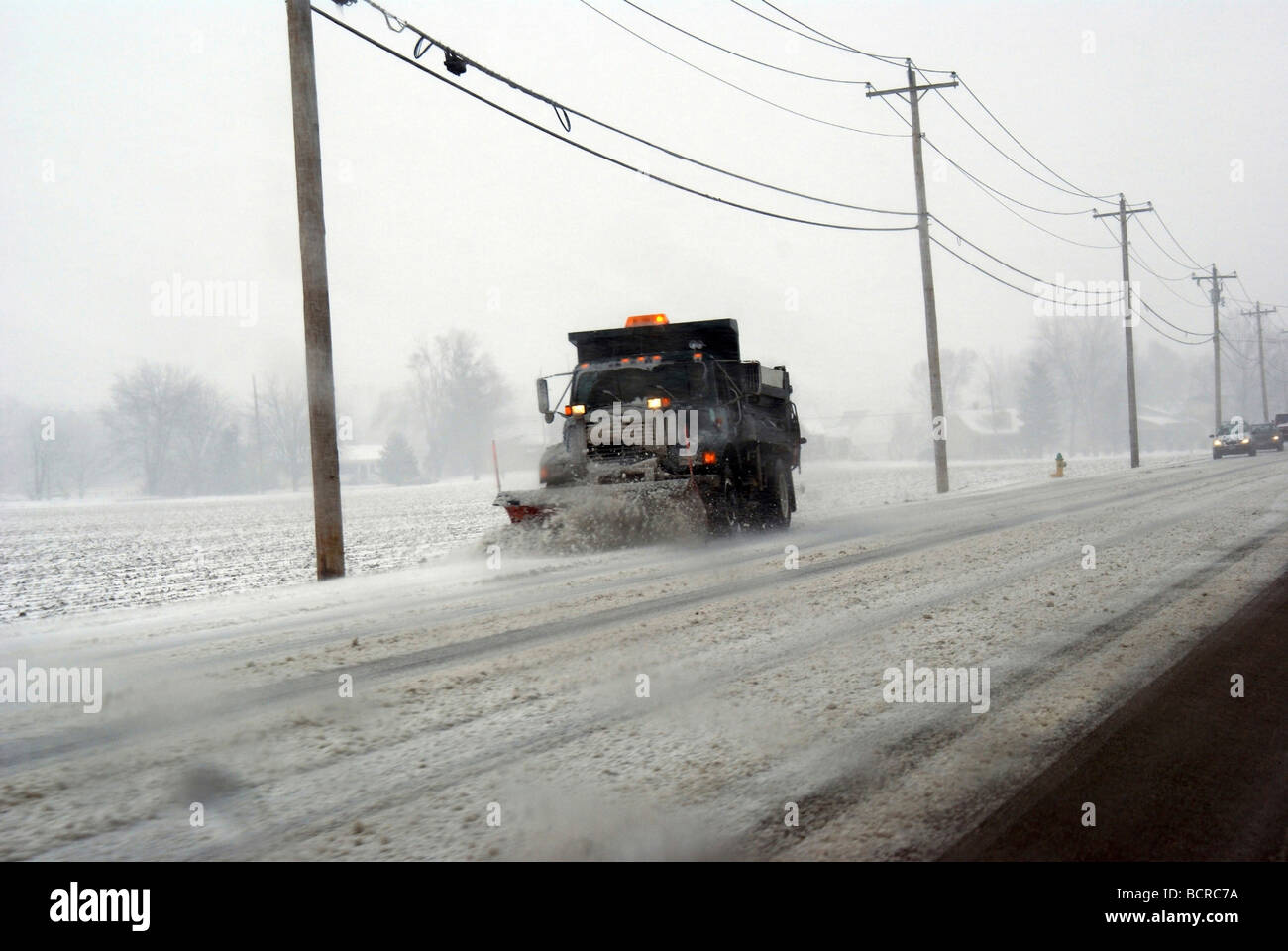 Snowplow cleaning snow from a road Stock Photo - Alamy