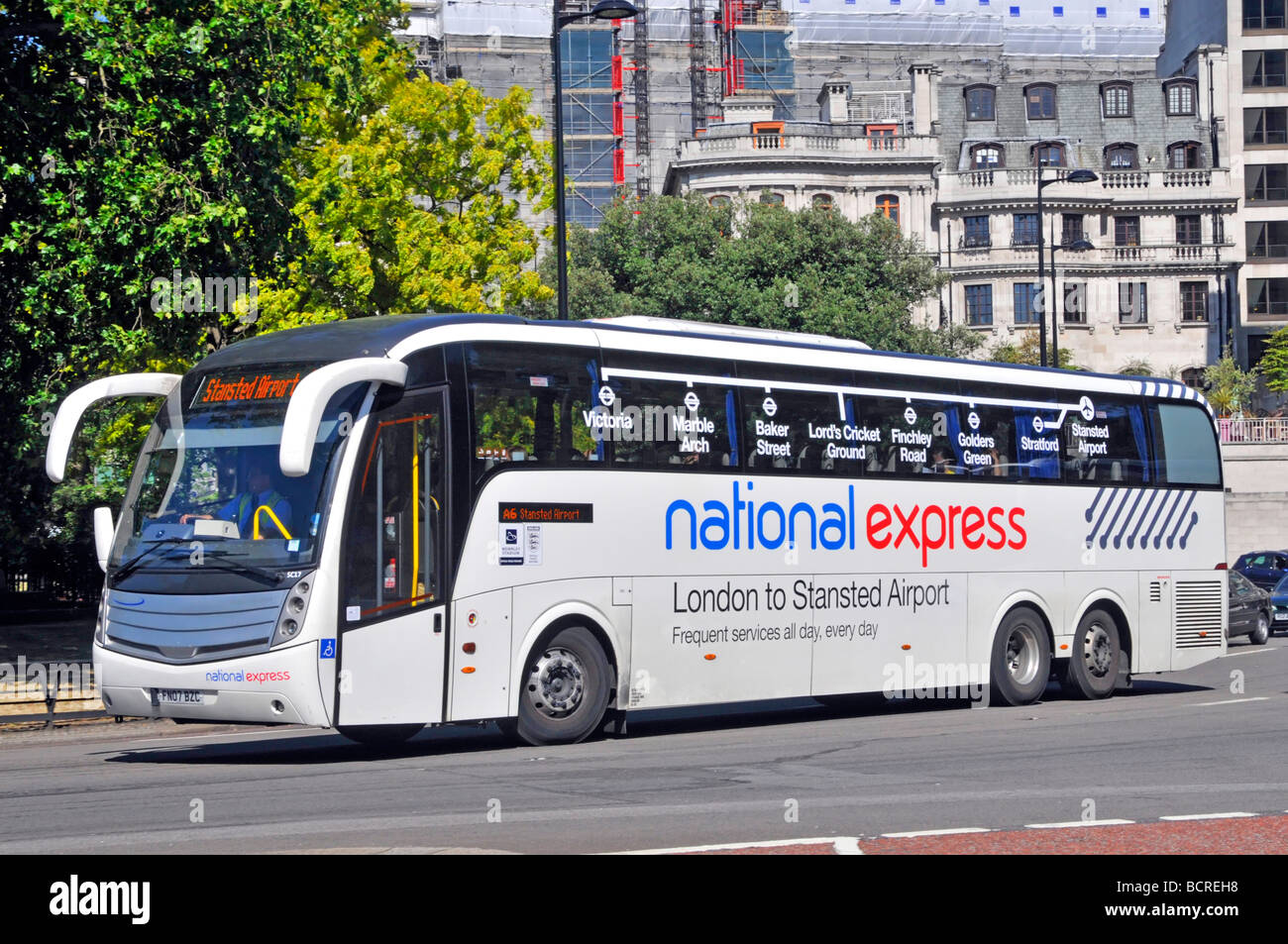Driver at work in National Express passenger coach service on Central London to Stansted Airport route seen in Park Lane London England UK Stock Photo