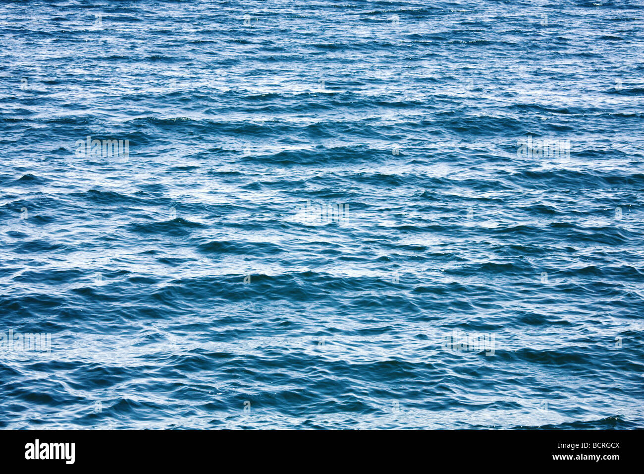 Azure sea water surface with ripple and cloud reflections Stock Photo ...