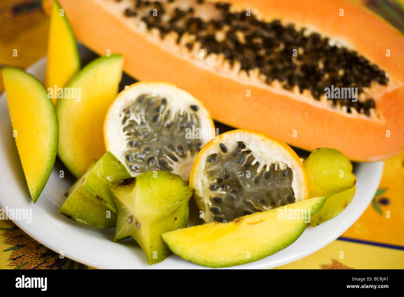 A plate of fruit with Passion fruit, Star fruit, Papaya and Mango