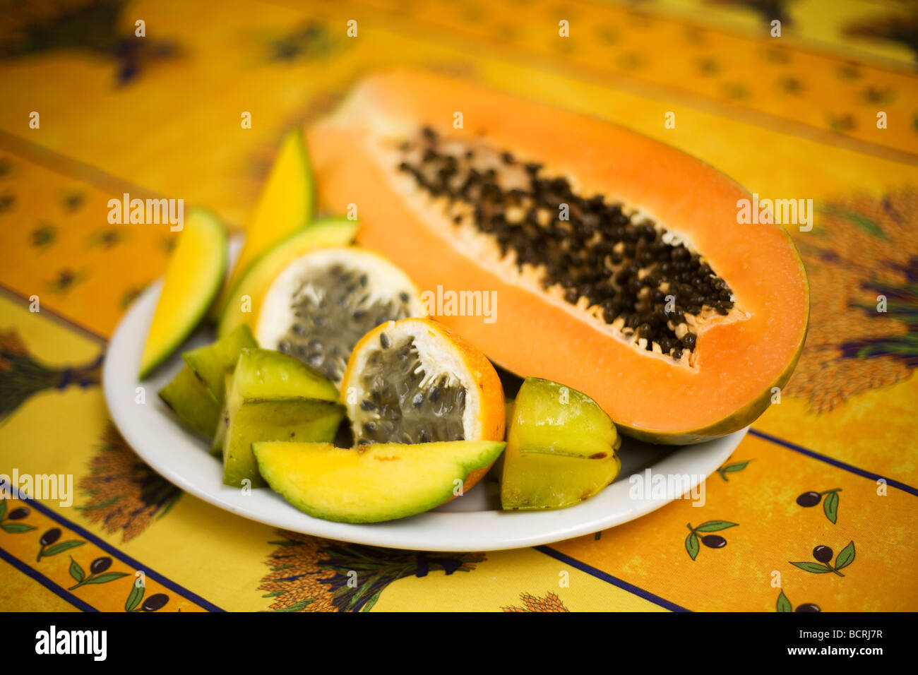 A plate of fruit with Passion fruit, Star fruit, Papaya and Mango