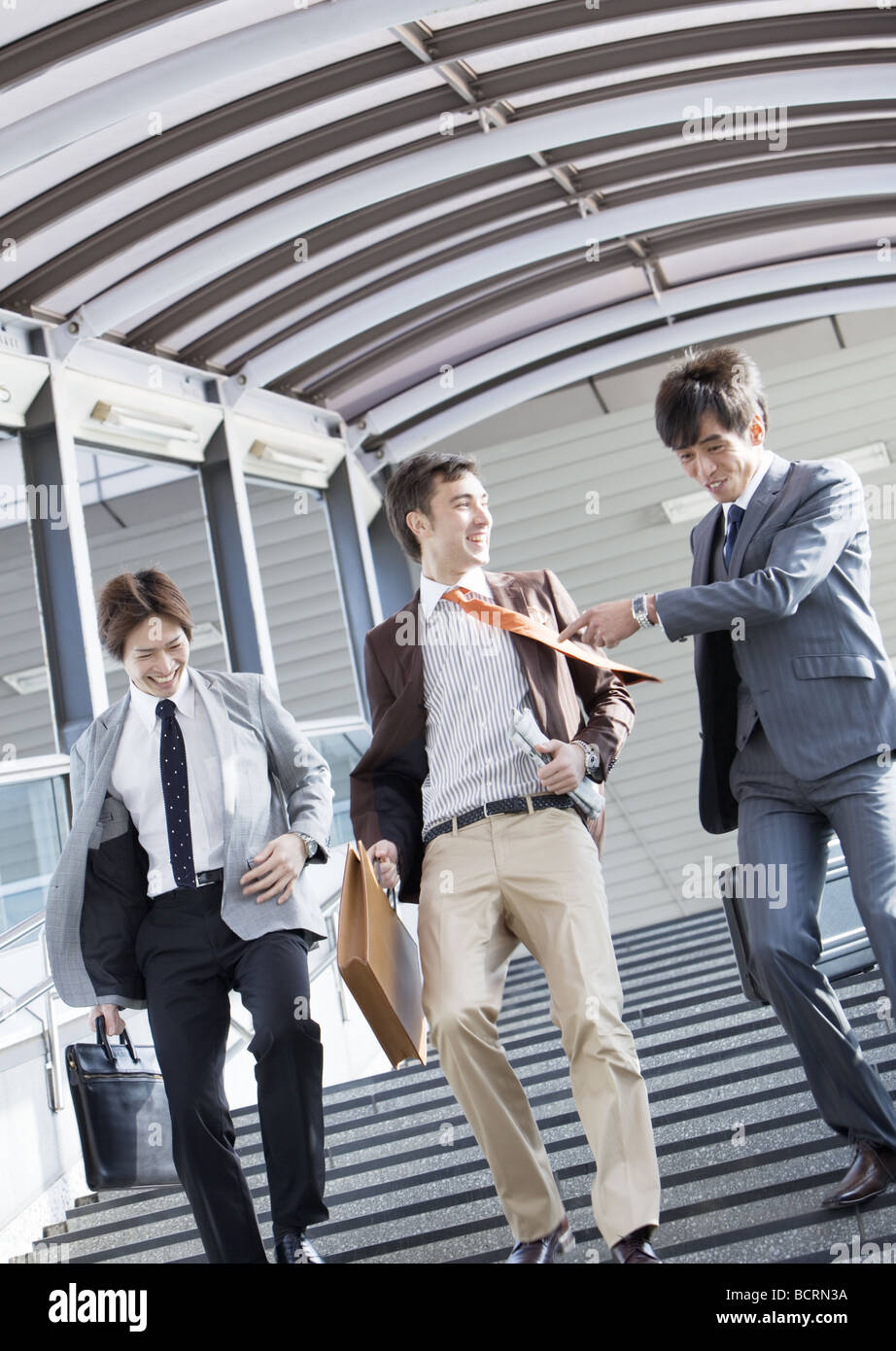 Businessmen walking down stairs Stock Photo - Alamy