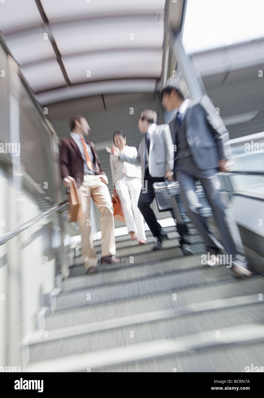 Businessmen and businesswoman walking down stairs Stock Photo - Alamy