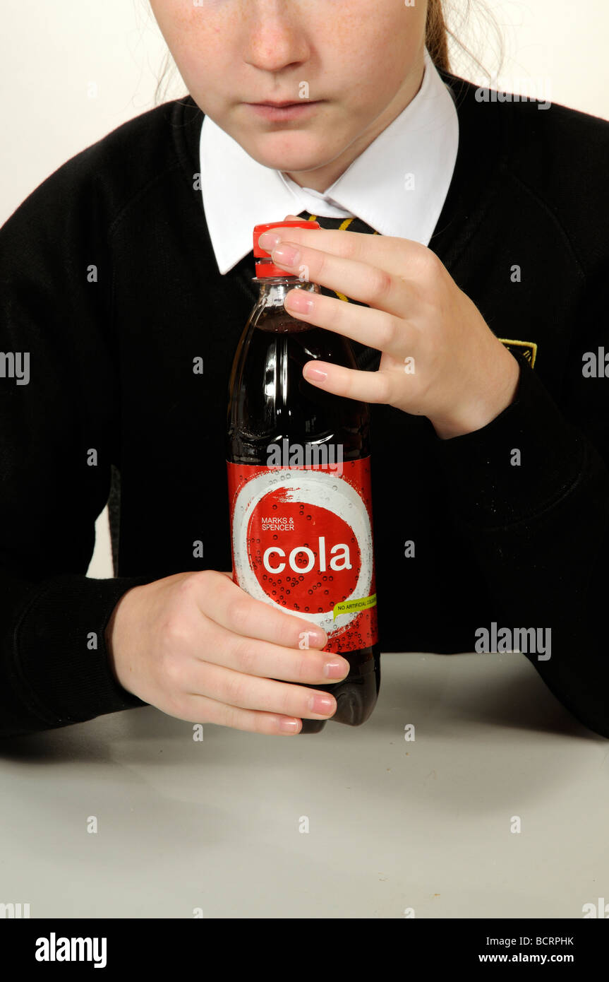 Child opening a plastic bottle containing a cola drink Stock Photo