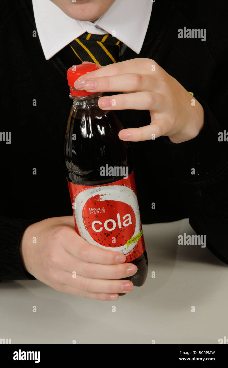 Child opening a plastic bottle containing a cola drink Stock Photo