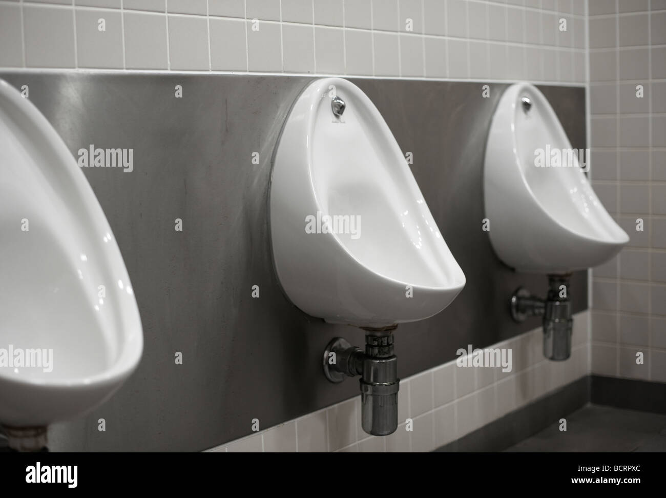 Three mens urinals in public toilet Stock Photo