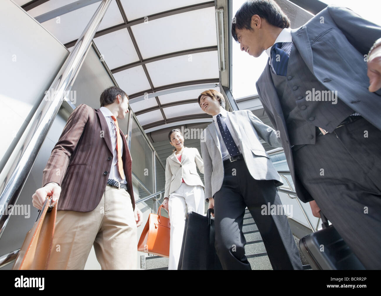 Businessmen and businesswoman walking down stairs Stock Photo - Alamy