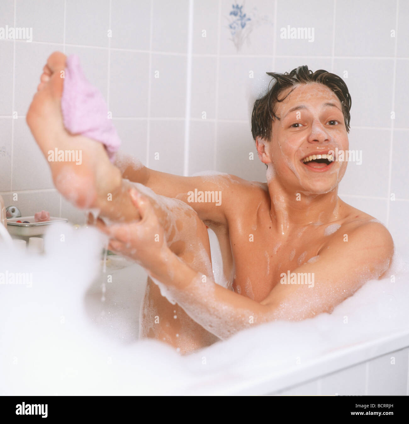 Teenage boy bathing with foam Stock Photo - Alamy