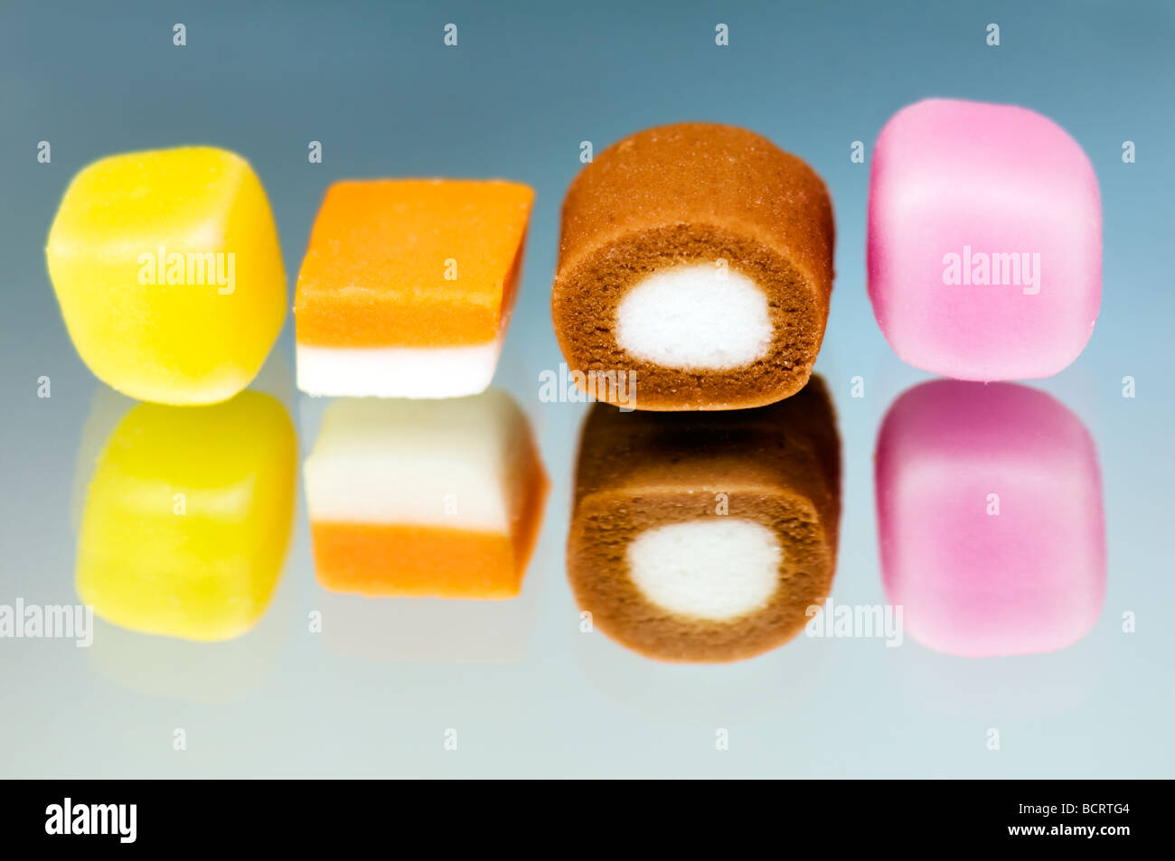 Close up of dolly mixture sweets in row with reflection in glass Stock Photo