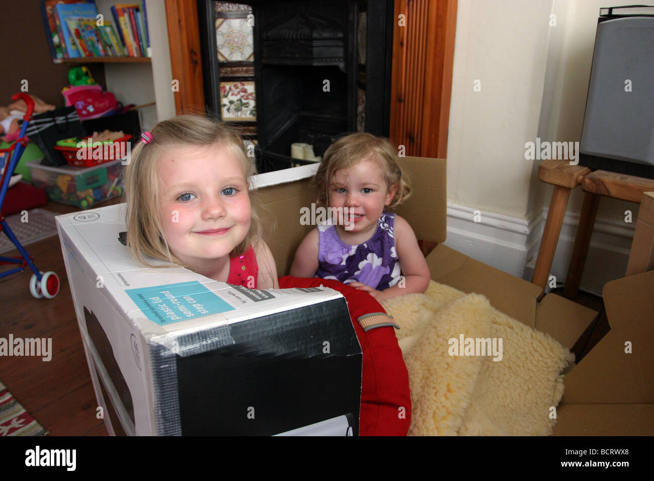 Two children playing in a cardboard box Stock Photo