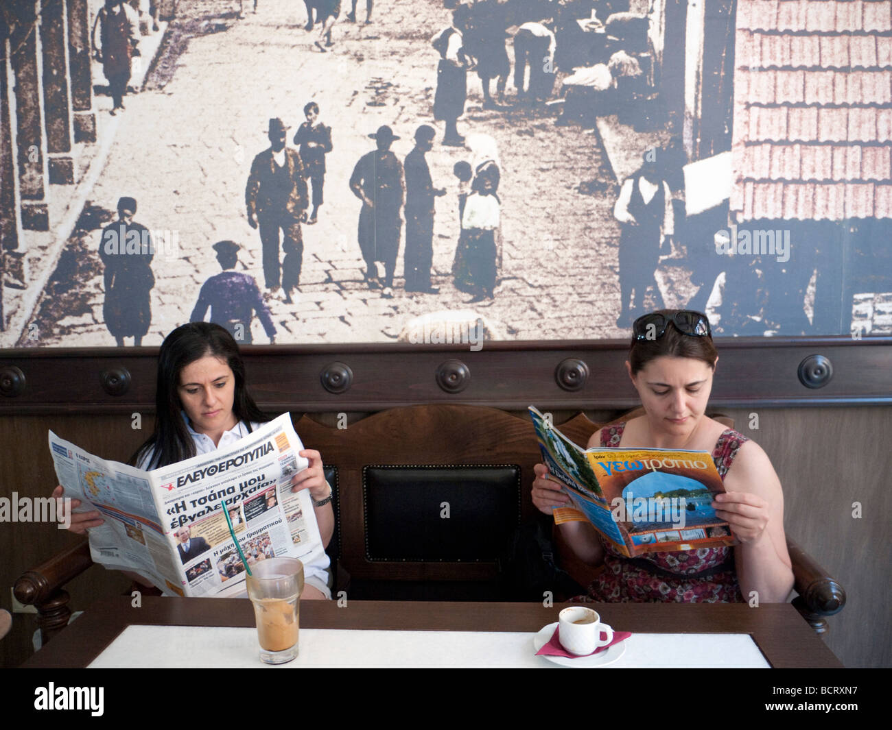 Two Greek women reading in traditional cafe in Mytilini town on Lesvos Island in Greece Stock Photo