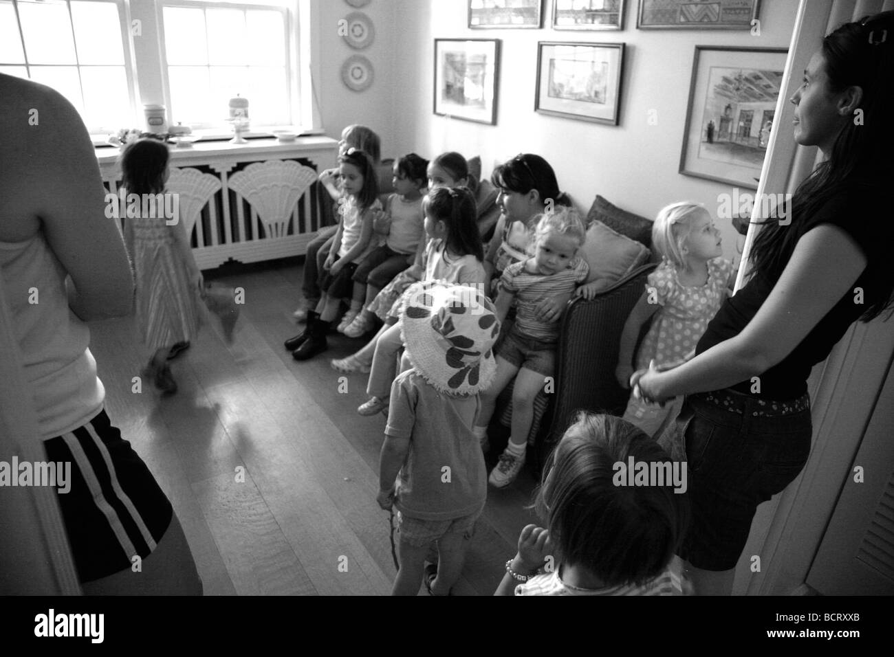 Black and white of children and parents in living room Stock Photo
