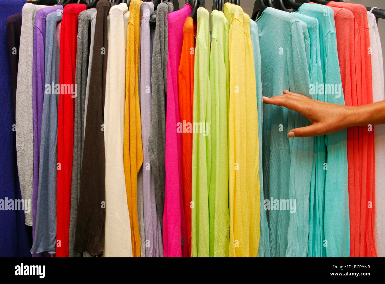 Woman perusing colourful garments in women's clothes store, Haslemere, Surrey, UK. Stock Photo