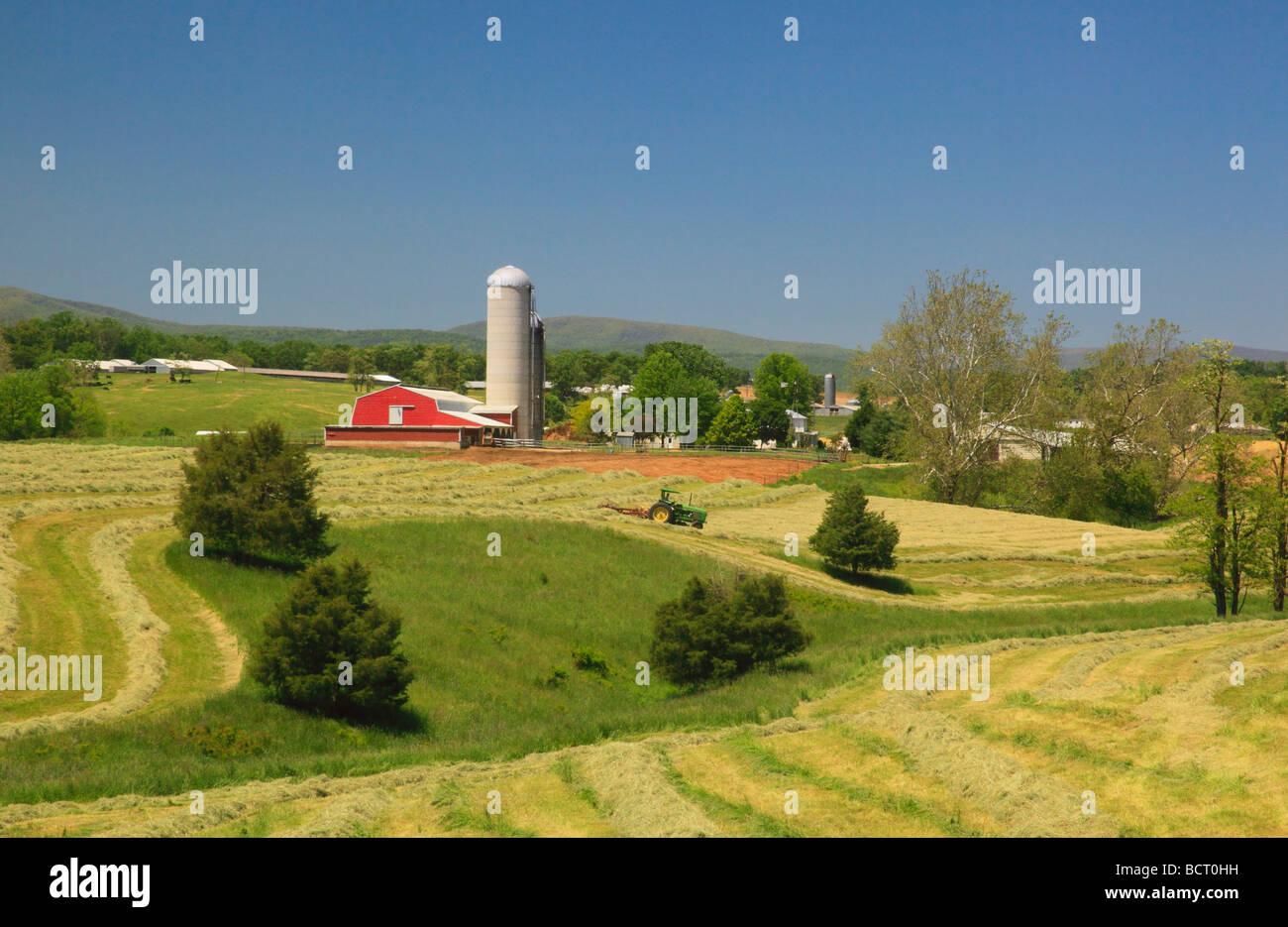 Mennonite farmer on tractor mows hay field on farm near Dayton in the