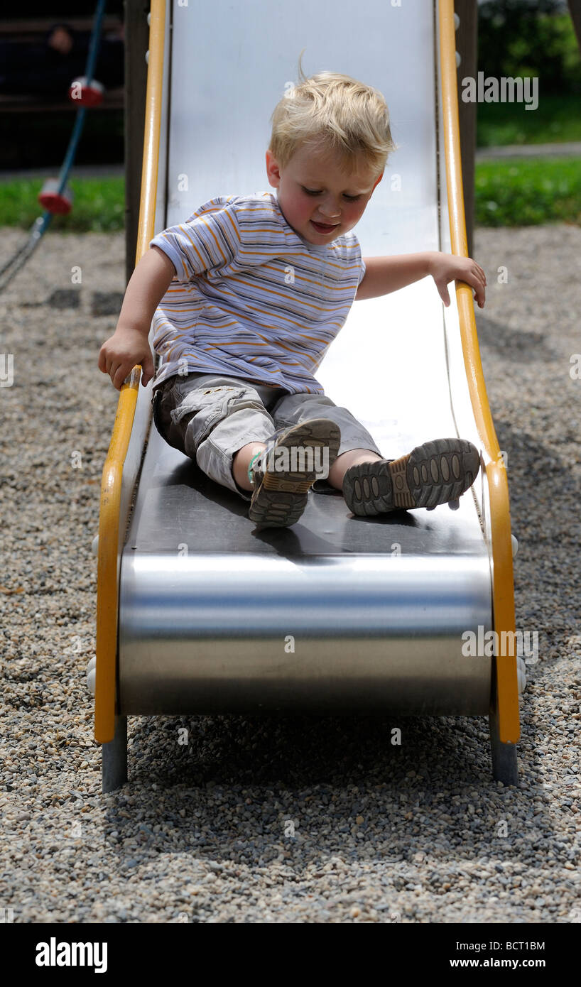 Cute little girl sliding down on slide in the playground 23059080