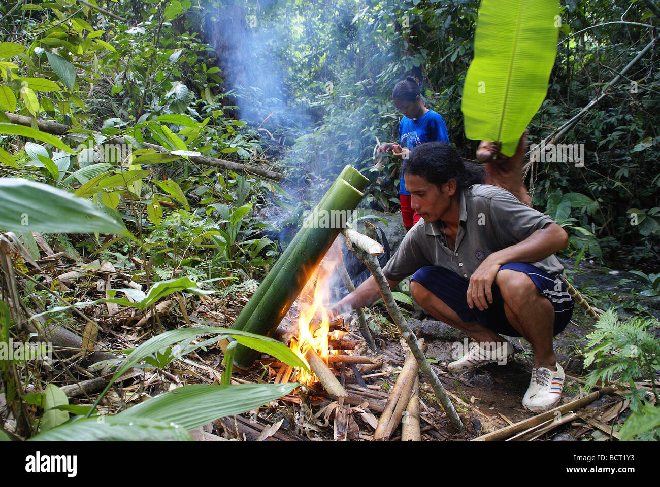 Cooking in bamboo over an open fire in the jungle Stock Photo Alamy