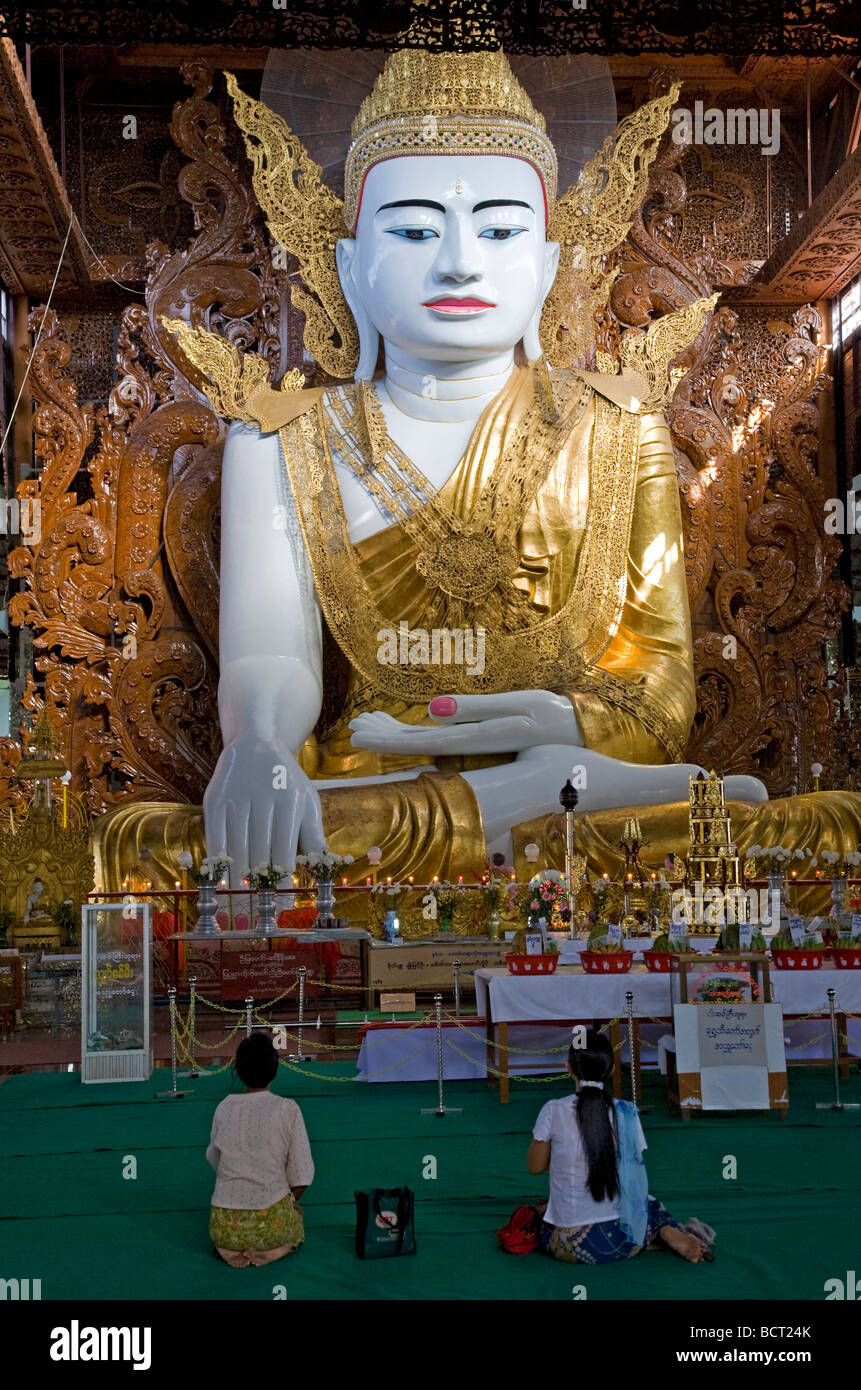 Burmese women worshiping the huge seated Buddha. Ngahtatgyi Paya ...
