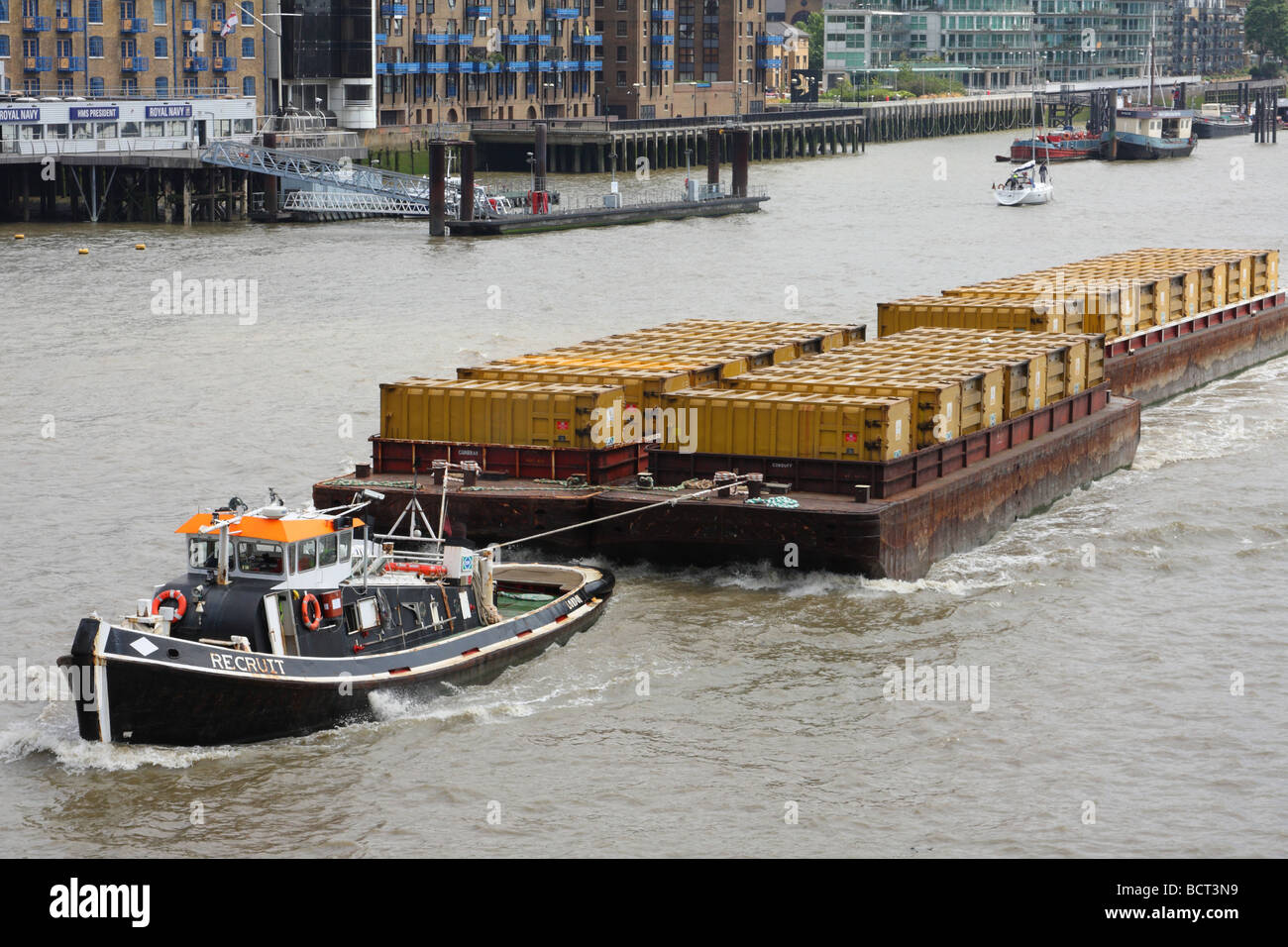 Cargo barges transporting containers on the River Thames at Tower