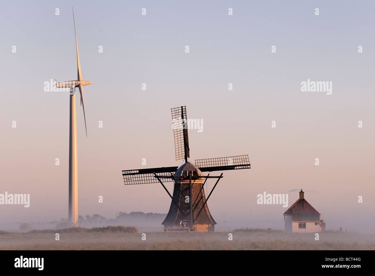 Wind turbine and windmill. De Babuurstermolen, Tjerkwerd, Friesland, Netherlands. Stock Photo