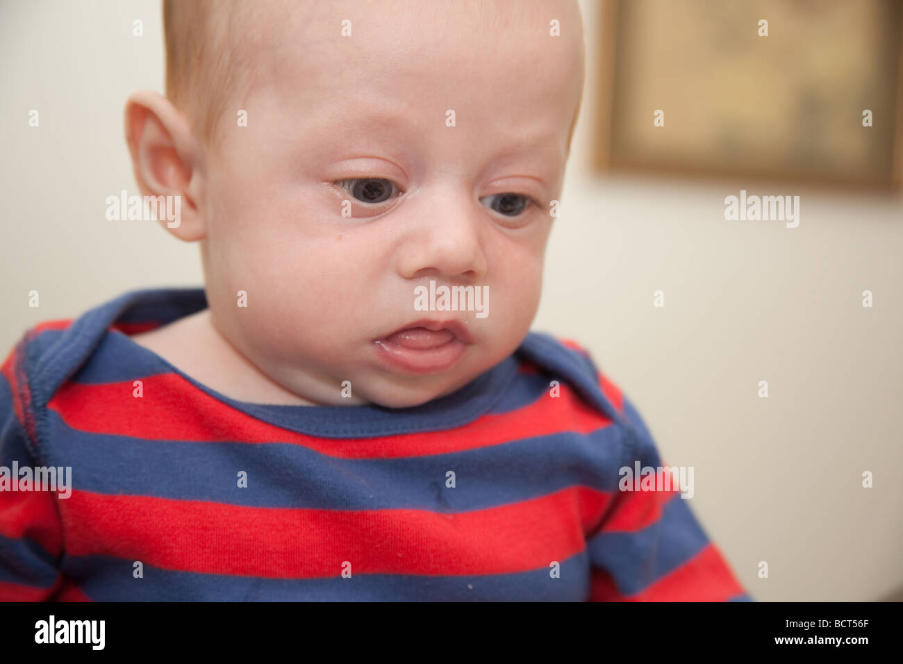 Two month old baby boy wearing a red and blue striped suit, London, England. Stock Photo