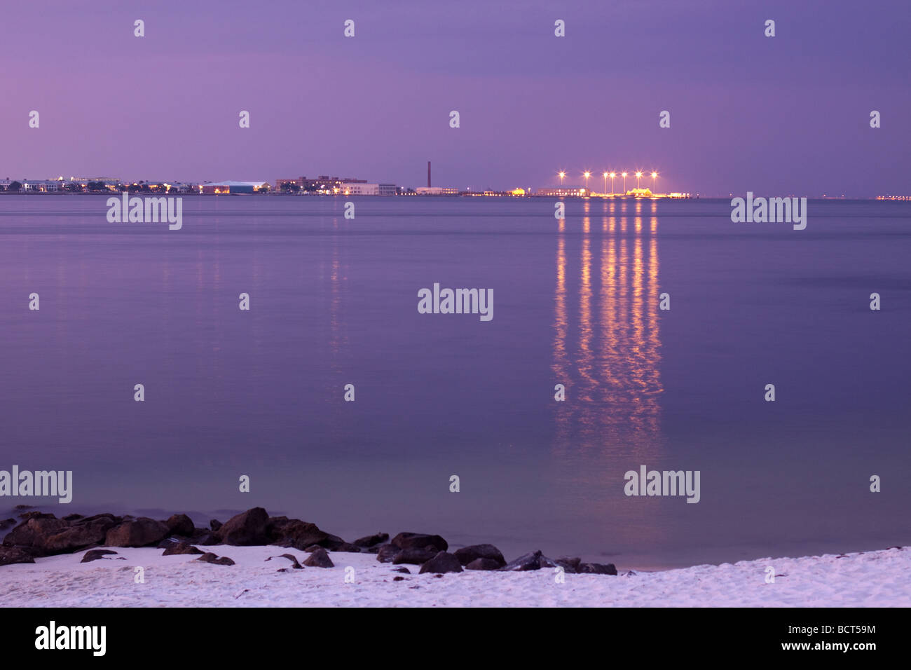 A light reflecting on water scene of Pensacola Bay at dusk looking Northeast towards the Naval Air Station from Ft Pickens. Stock Photo