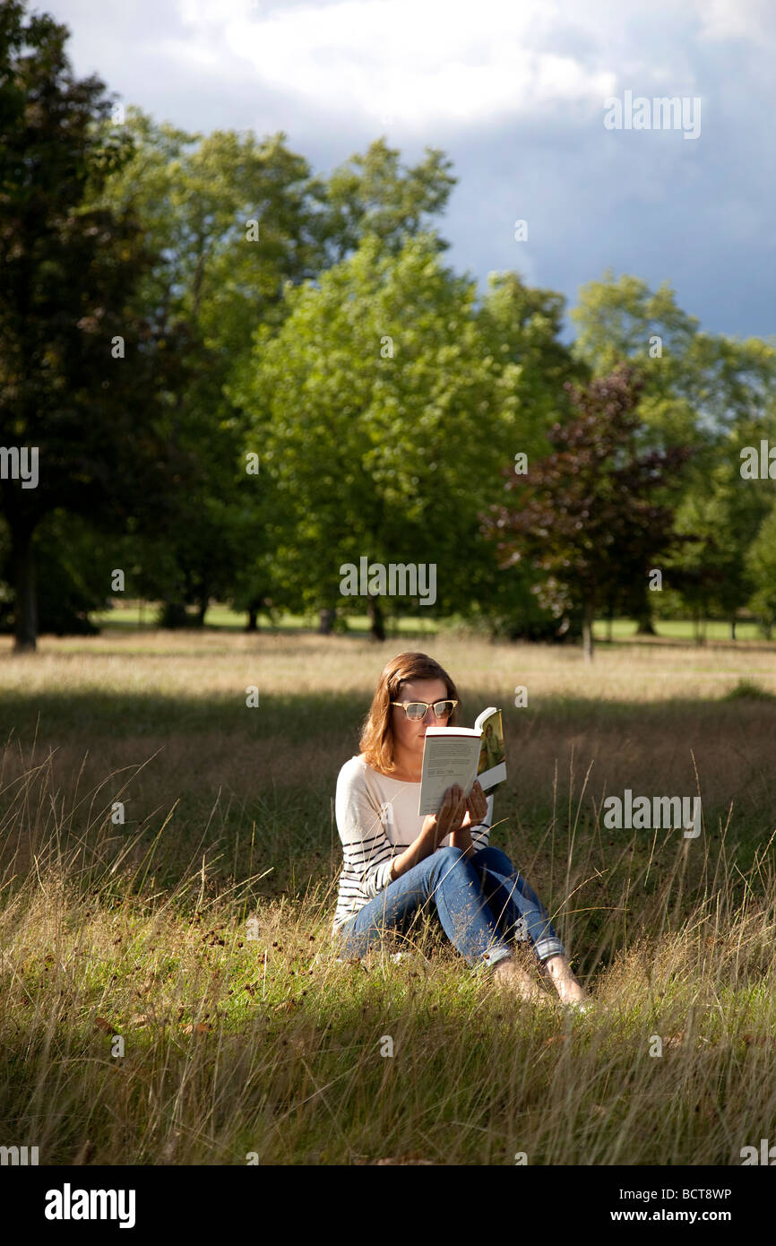 Girl reading outside in the park Stock Photo