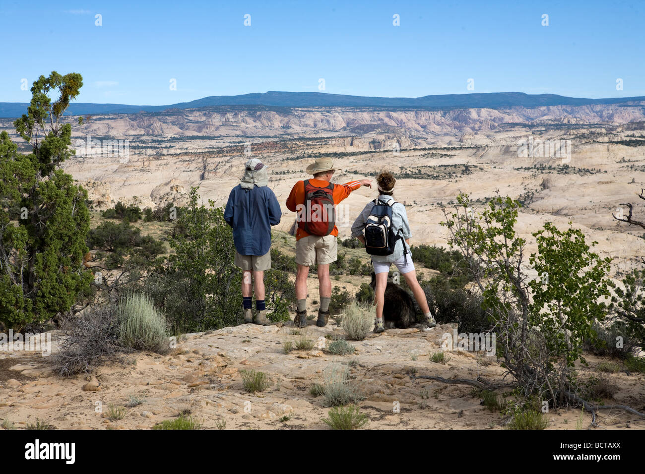 Visitors to the Grand Staircase Escalante National Monument Utah looking at the landscape while taking a break during a hike Stock Photo